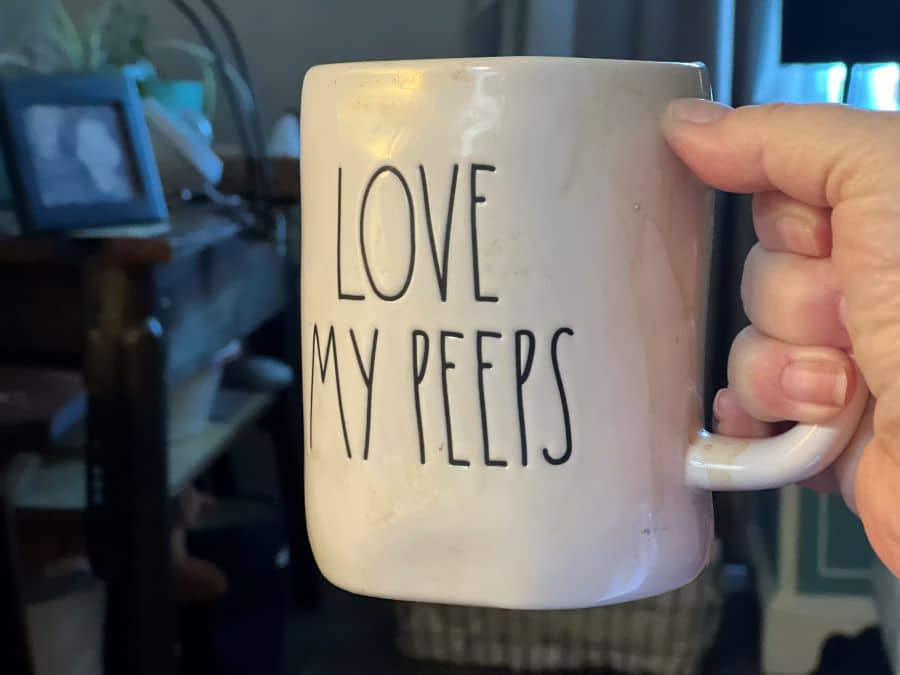 coffee cup with love my peeps written on it held by a white hand