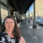 Becky McCray with downtown street and business behind her