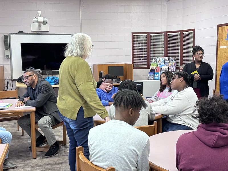 students sitting around a table working on their Idea Friendly project