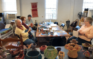 group of women sitting around a table making crafts