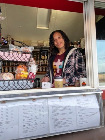 drive through coffee shop in colorado woman with dark hair smiling and serving coffee
