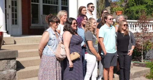 a group of content creators post in front of a historic building in Lansing MI