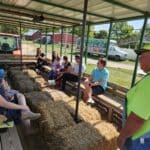 content creators riding on a wagon with hay bales