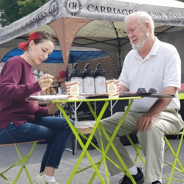 an older man and a young woman drinking coffee