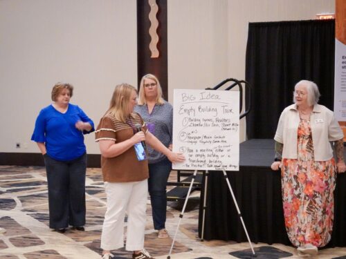 3 people presenting their idea friendly project and Deb commenting