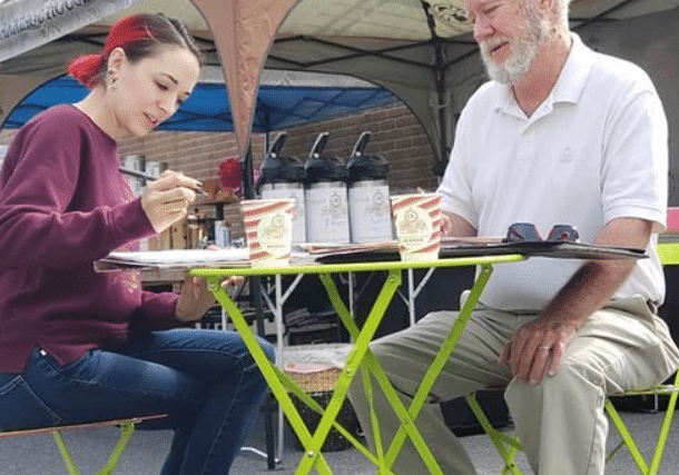 an older man and a young woman drinking coffee