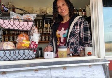 drive through coffee shop in colorado woman with dark hair smiling and serving coffee