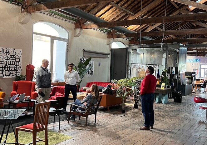 inside the NOW beato coworking location in lisbon with high ceilings, hardwood floors, lots of big windows for great light and people working