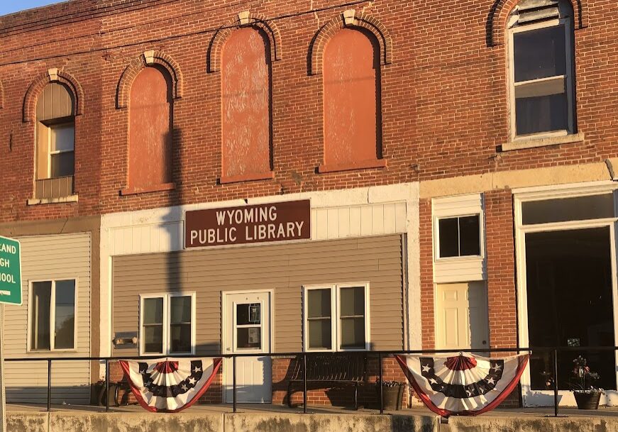 two story brick building with empty 2nd story and bunting on the railing